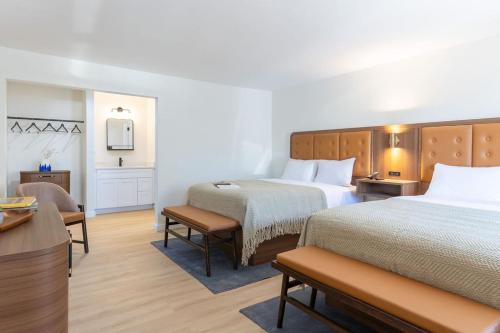 a hotel room with two beds and a desk at Salt Ranch Hotel in Nashville