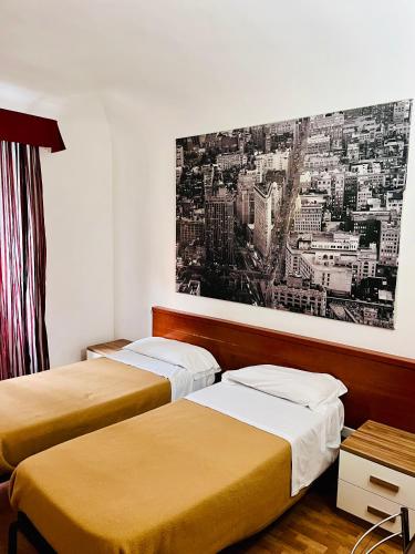 two beds in a room with a painting on the wall at Beauty Holidays in Rome