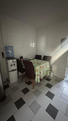 a room with a table and chairs and a kitchen at Quarto privativo confortável próximo a ufba, praia, comercio e zoológico in Salvador