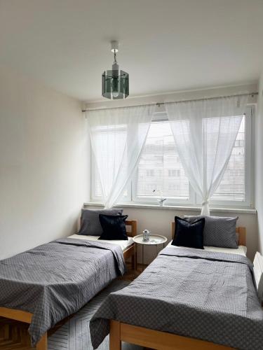 two beds in a room with a window at Relax Visoko Apartman in Visoko