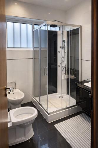 a bathroom with a shower and a toilet and a sink at Vikap Guest House in Porto