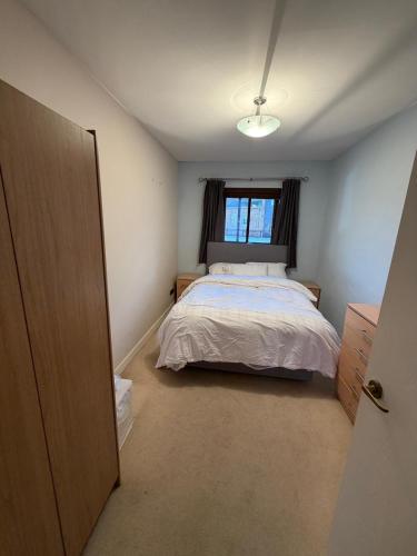 a small bedroom with a bed and a window at Elegant 1-Bedroom Flat With Stunning Thames views in Kingston upon Thames