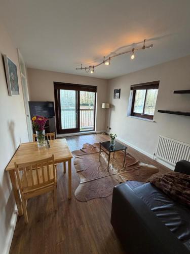 a living room with a table and a couch at Elegant 1-Bedroom Flat With Stunning Thames views in Kingston upon Thames