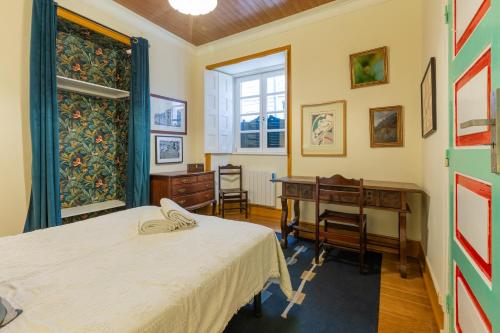 a room with two beds and a desk and a window at Casa de Santa Rita in Chaves