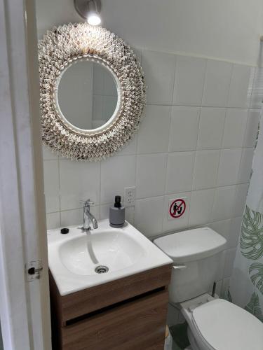 a bathroom with a sink and a mirror and a toilet at Blue Lagoon Apartment in Lagun