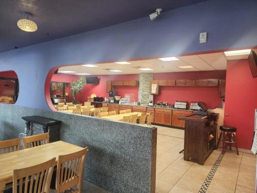 a restaurant with wooden tables and chairs and a counter at Alex Hotel and Suites Anchorage Airport in Anchorage