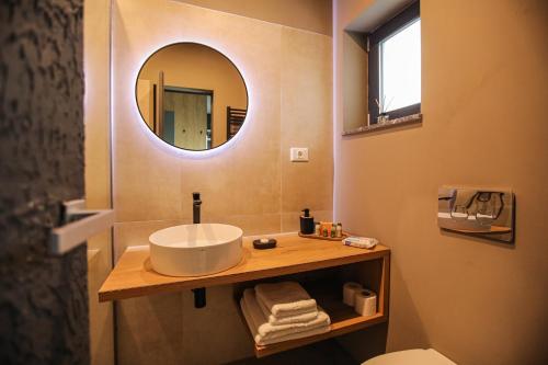 a bathroom with a sink and a mirror at Poiana Events - Vilă privată cu piscină aproape de Mamaia și Constanța in Poiana