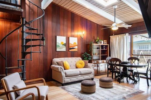 a living room with wood paneling and a spiral staircase at Spacious 4BR Backyard Oasis with BBQ Near UC Davis in Davis