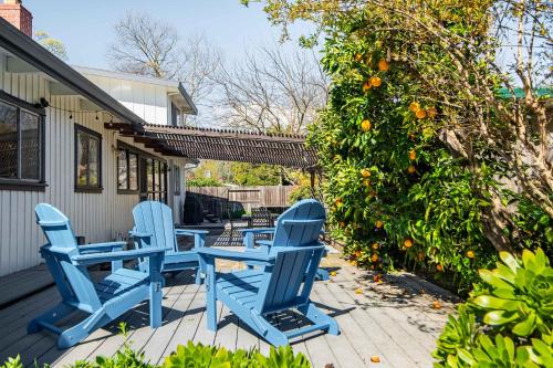 a group of blue chairs on a porch with an orange tree at Spacious 4BR Backyard Oasis with BBQ Near UC Davis in Davis