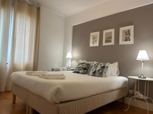 a bedroom with a large bed with two lamps at suites Lisboa areeiro in Lisbon