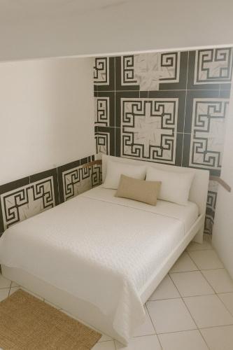a white bed in a room with a wall at Casa de Mainha in Salvador