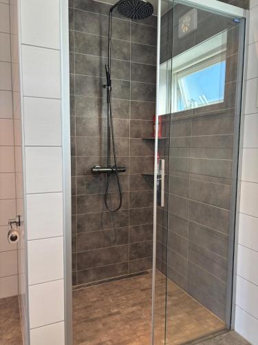 a shower with a glass door in a bathroom at 4-Bedroom Accommodation Near NTNU & Raufoss Business Area in Gjøvik