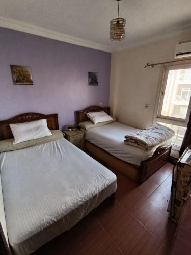 a bedroom with two beds and a window at Rest and relaxation in Madinaty