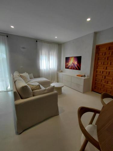 a living room with a couch and a tv on the wall at Casa Mimo Altea in Altea