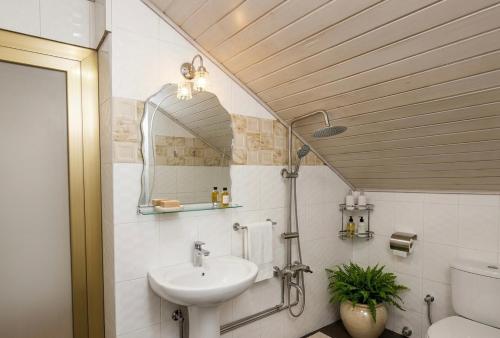 a bathroom with a sink and a toilet and a mirror at LKL appartements in Kinshasa