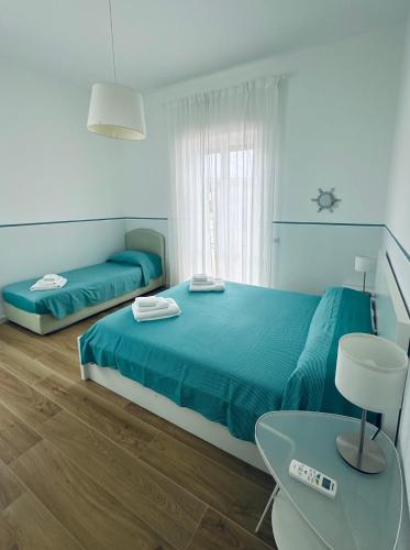 a bedroom with two beds and a table and a chair at Blu Bolivar in Marina di Camerota
