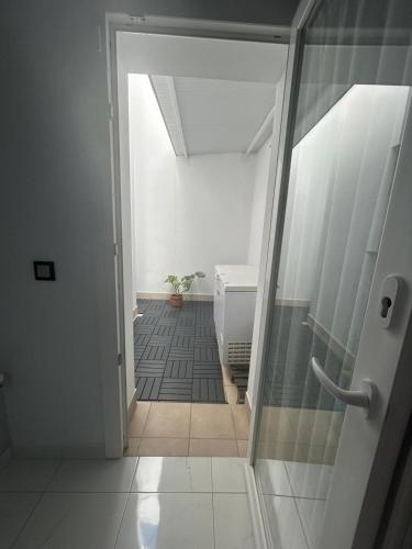 a bathroom with a glass door leading to a hallway at Chalet con 3 habitaciones Luz De Doñana in Mazagón