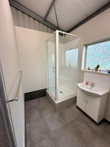 a bathroom with a shower and a sink at Vineyard Cabin in Te Kauwhata
