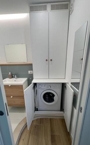 a washing machine in a kitchen with white cabinets at Blu Bolivar in Marina di Camerota