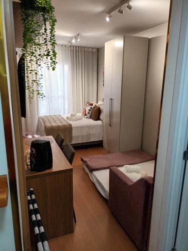 a hotel room with two beds and a mirror at Studio Itaú Metrô Conceição in São Paulo