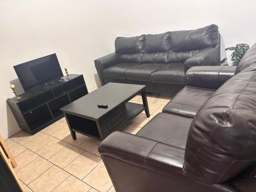 a living room with a leather couch and a table at Casa amplia in Ciudad Juárez