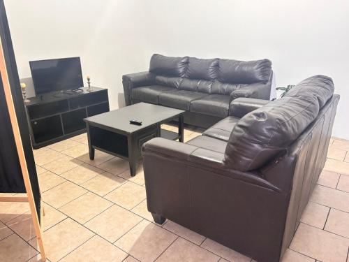 a living room with a leather couch and a table at Casa amplia in Ciudad Juárez