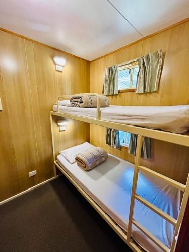 a small room with three bunk beds in it at River Bend Caravan Park in Kanyapella