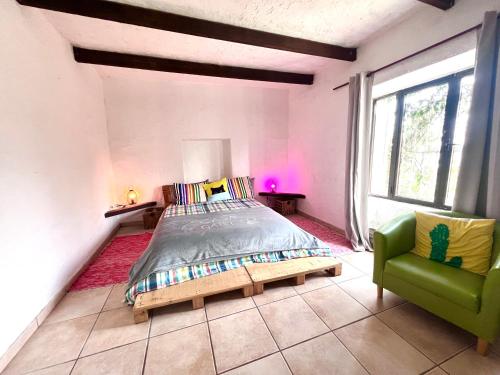 a bedroom with a bed and a green chair at Casa Gatti - Casa del '900 nel centro di Lanzarote - Relax tra i Vulcani in Tiagua