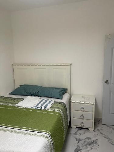a bedroom with two beds and a night stand at Villa Rivera in Boca Chica