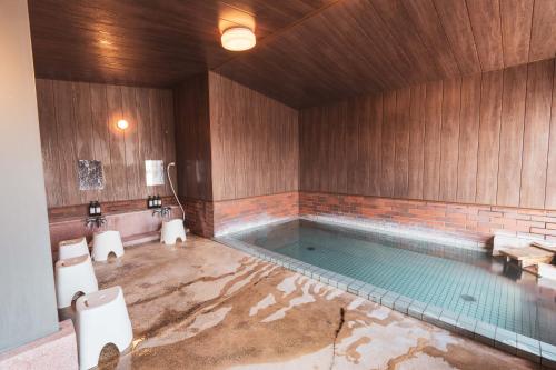 a bathroom with a swimming pool with two toilets at Juniya Myoko in Myoko