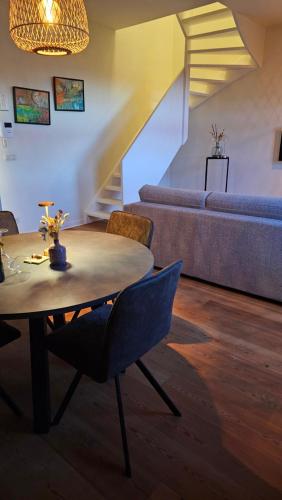 a living room with a table and a couch at B&B T'Rest - Park ter Rijst in Heikruis