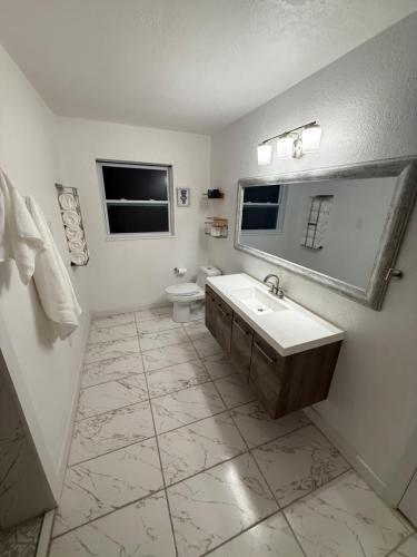 a bathroom with a sink and a toilet and a mirror at Welcome to Highland Shore in Ellenton