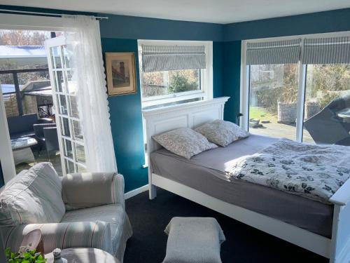 a bedroom with a bed and a chair and a window at Den Gamle Apotekergaard in Høng