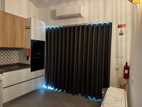 a black shower curtain in a kitchen with blue lights at Casinha do Areeiro in Loulé