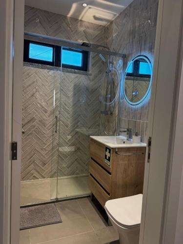 a bathroom with a shower and a toilet and a sink at Casinha do Areeiro in Loulé