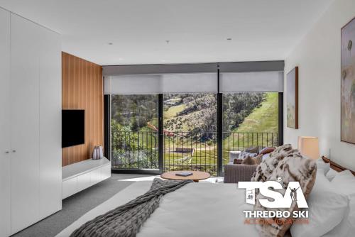 a living room with a couch and a tv at Black Bear 402 in Thredbo