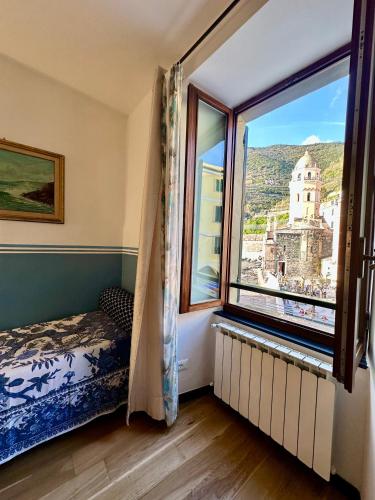 a bedroom with a window with a view of a city at The Vernazza Main Plaza - Rooms & Suites in Vernazza