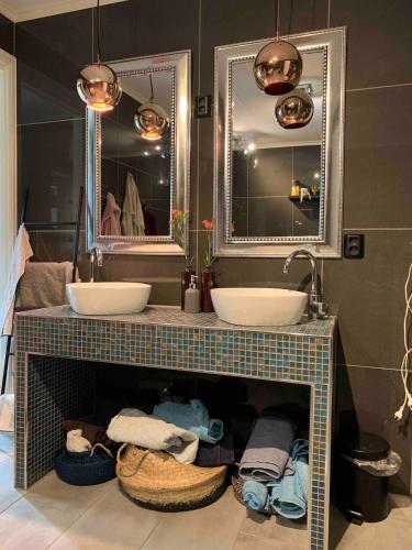a bathroom with two sinks and two mirrors at Raufoss Villa Residence in Raufoss