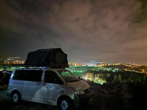a white van with luggage on top of it at night at Camper Van For Rent In Albania in Tirana