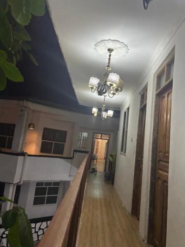 a hallway in a house with a chandelier at Manch Lodge Vuga Zanzibar in Zanzibar City