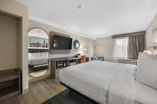 a hotel room with a bed and a flat screen tv at La Quinta by Wyndham Nashville Airport/Opryland in Nashville