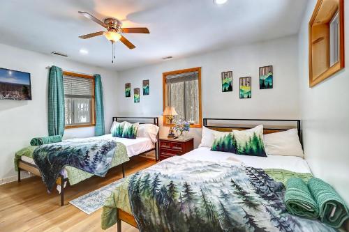 a bedroom with two beds and a ceiling fan at 6BR Luxury Mountain Retreat - Hot Tub, Game Room, Lake, Beach, Karaoke, Bar, Poconos in Albrightsville