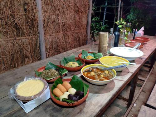 a wooden table with bowls of food on it at Hijoltola Camping & Resort in Kumāran