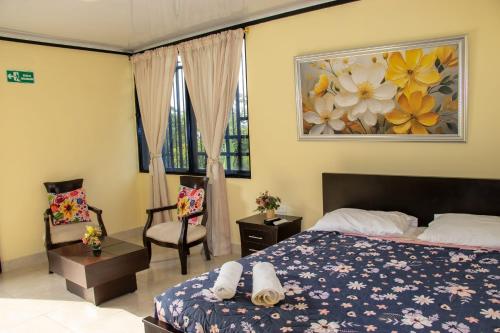 a bedroom with a bed and a chair and a painting at Alojamiento Rural Casa de Campo Erika Sofia in Rivera