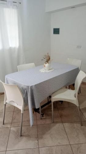 a table with white chairs and a blue table cloth at El Amuleto in Rivadavia