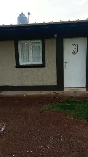 a building with a white door and a window at El Amuleto in Rivadavia