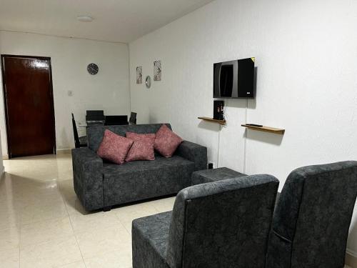 a living room with a couch and chairs and a tv at Apartamento Albergue - Buga in Buga