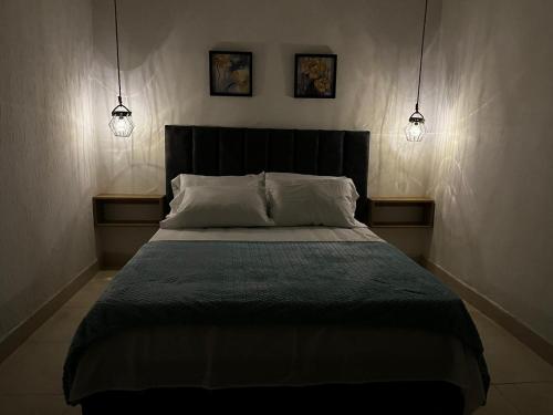 a bedroom with a bed with two lights above it at Apartamento Albergue - Buga in Buga