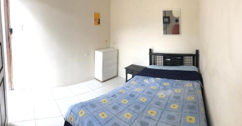 a bedroom with a bed and a dresser in it at Habitación orégano in Santa Elena