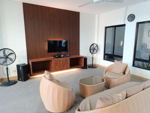 a living room with a couch and chairs and a television at Michaels Spring Resort, Natural Hot Spring in Calamba